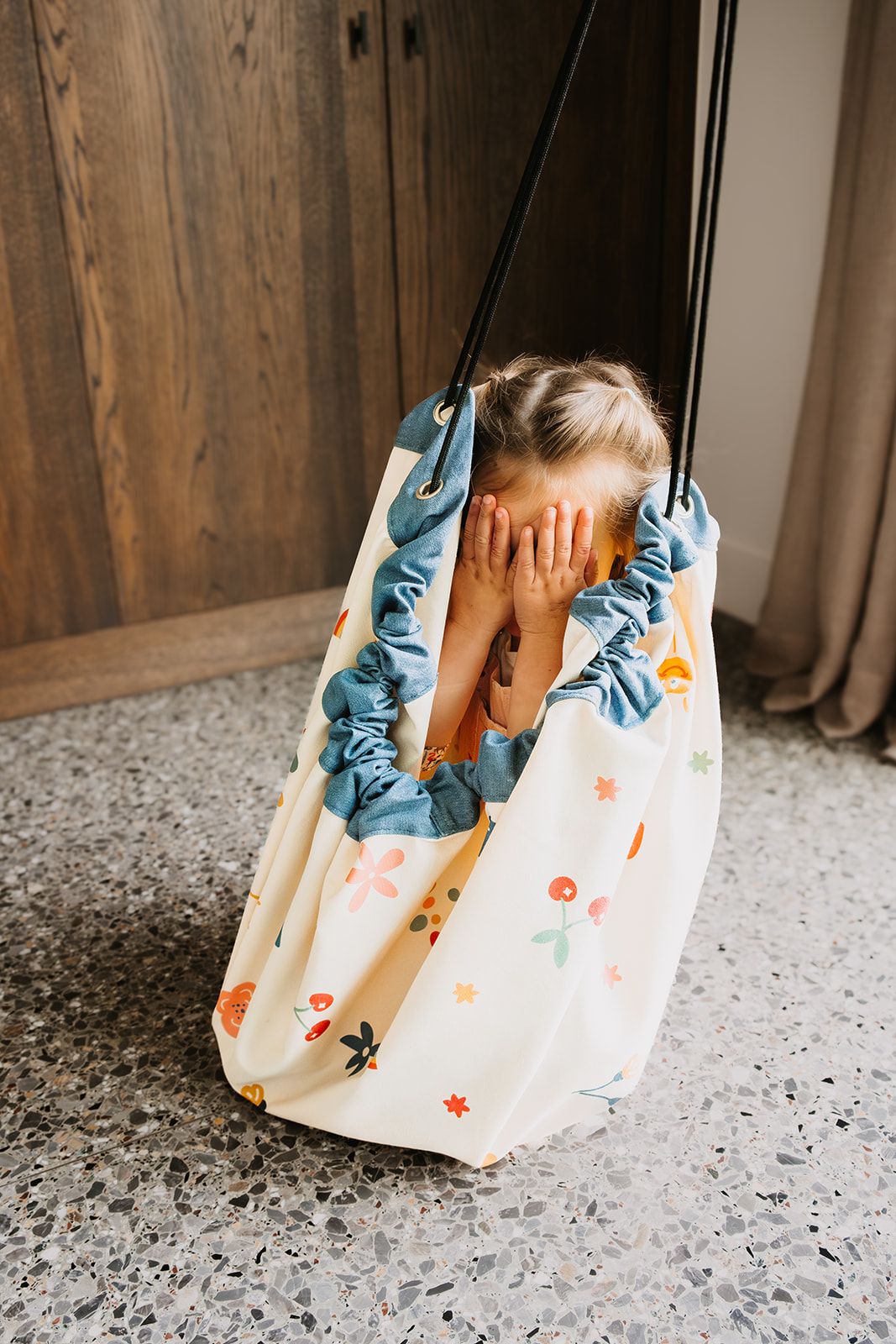 funny days toy storage bag and playmat, child is sitting in the bag, playing hide and seek