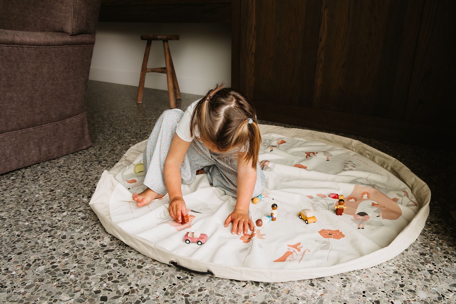 fairyworld toy storage bag and playmat, child is playing on the mat with wooden toys