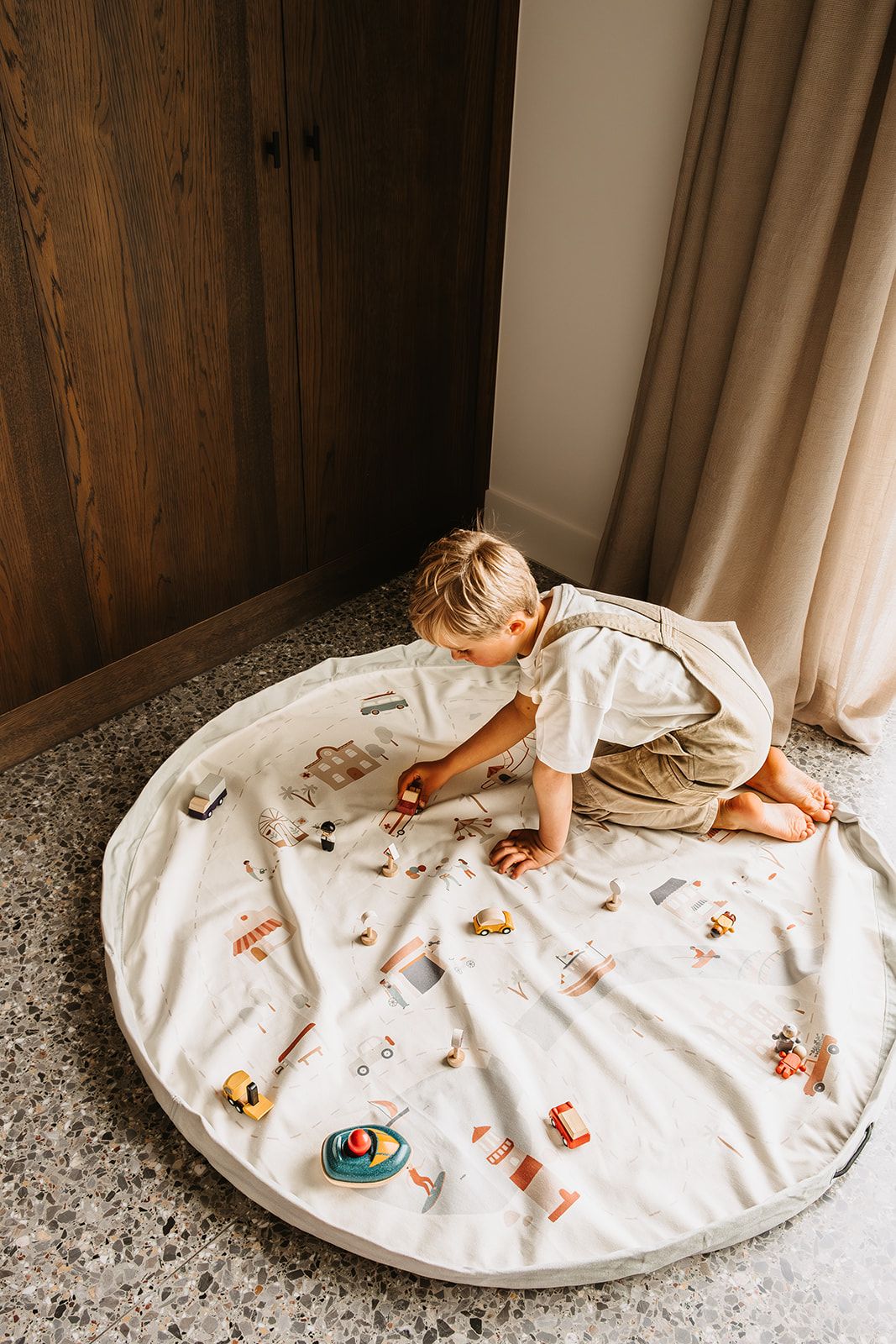 citymap toy storage bag and playmat, child is playing on the mat