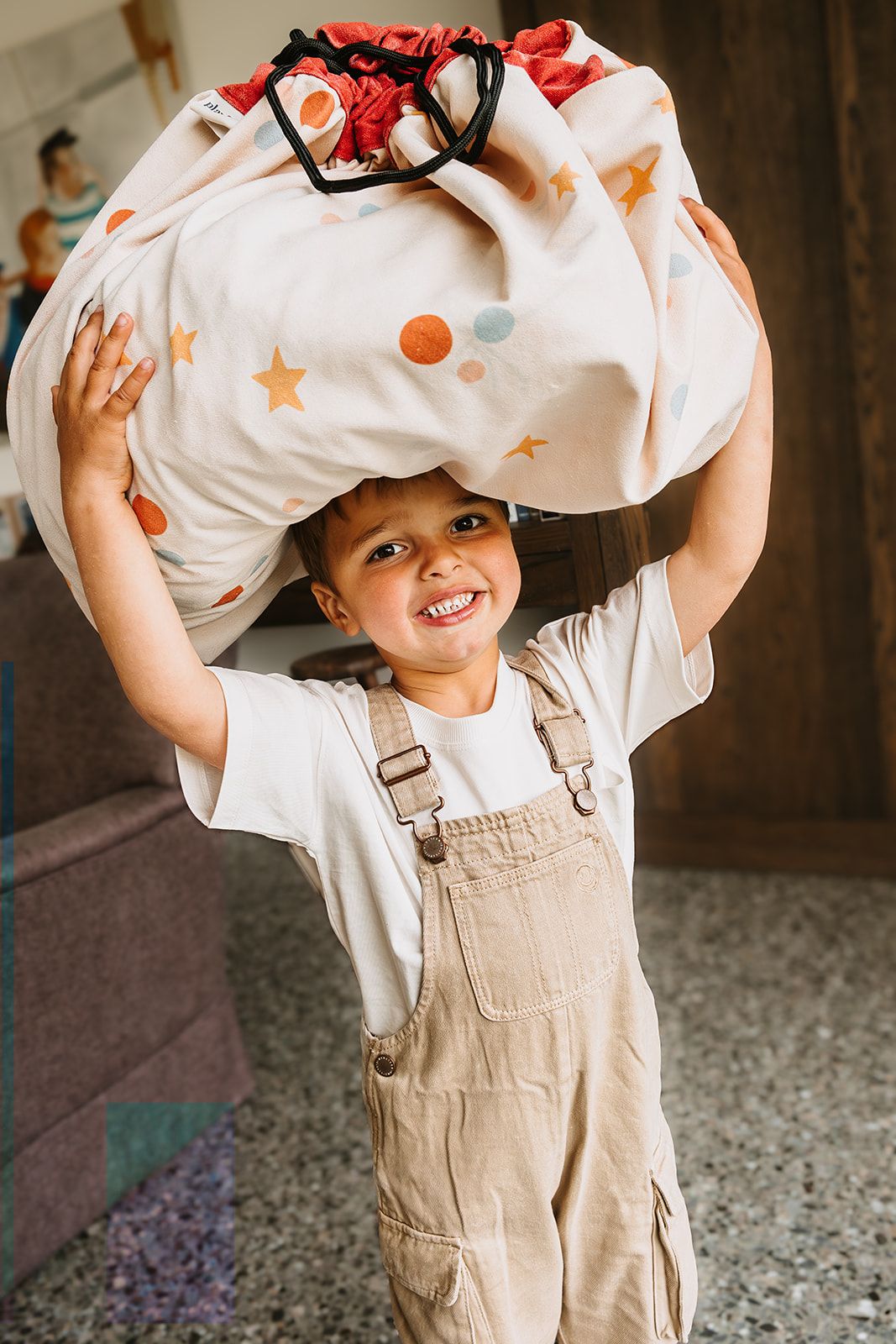 circus toy storage bag and playmat, child is carrying the bag on its head