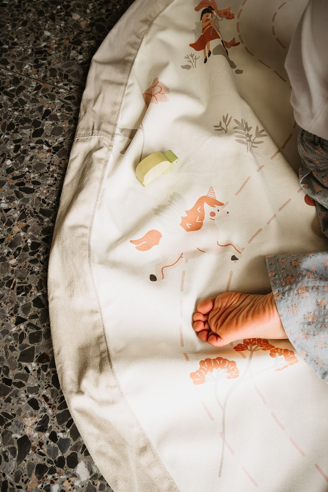 fairyworld toy storage bag and playmat, child is sitting on the mat