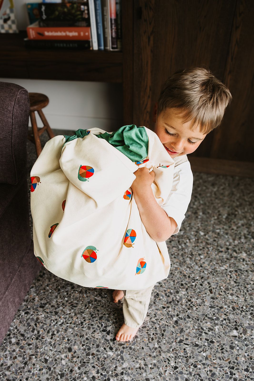 snails toy storage bag and playmat, child is carrying the bag