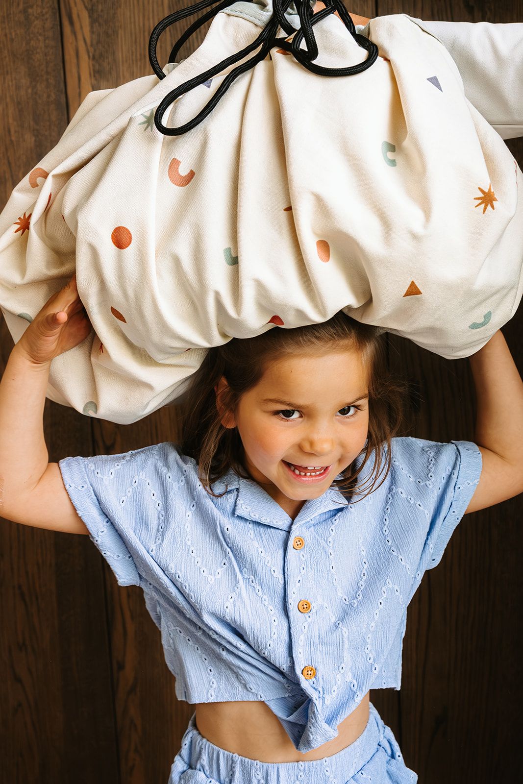 citymap toy storage bag and playmat, child is carrying the bag on the head
