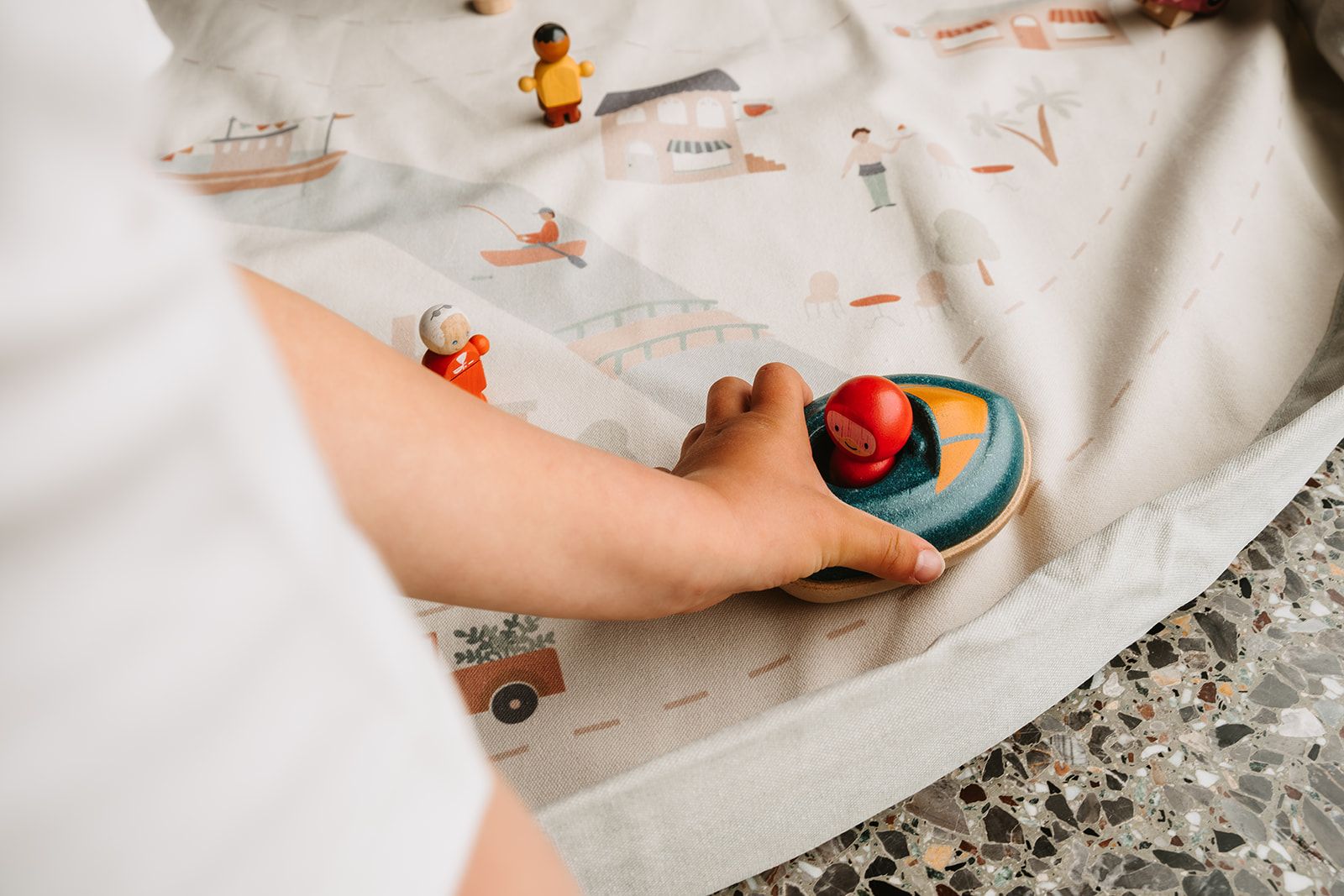 citymap toy storage bag and playmat, child is playing with wooden toys