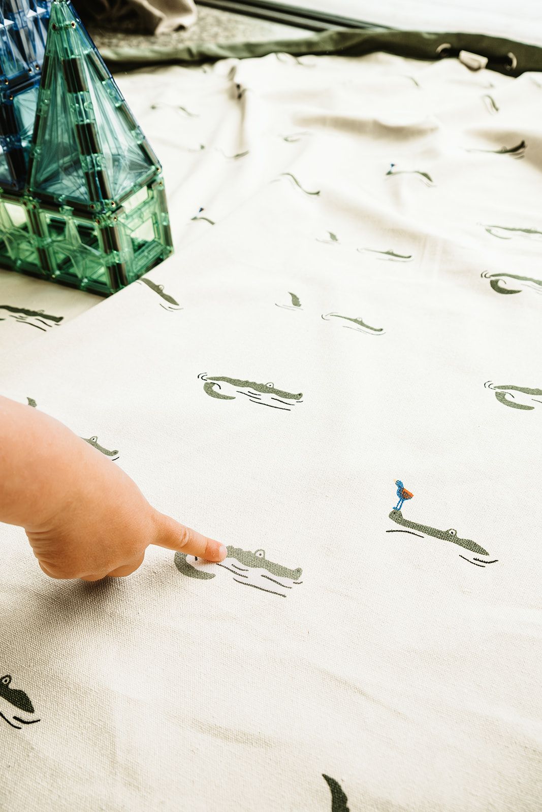 croco toy storage bag and playmat, child is pointing at the crocodile on the mat