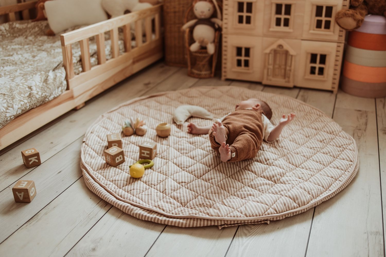 soft stripes brown organic babymat, little baby is lying on the mat, wooden blocks, kidsroom, victorian playhouse