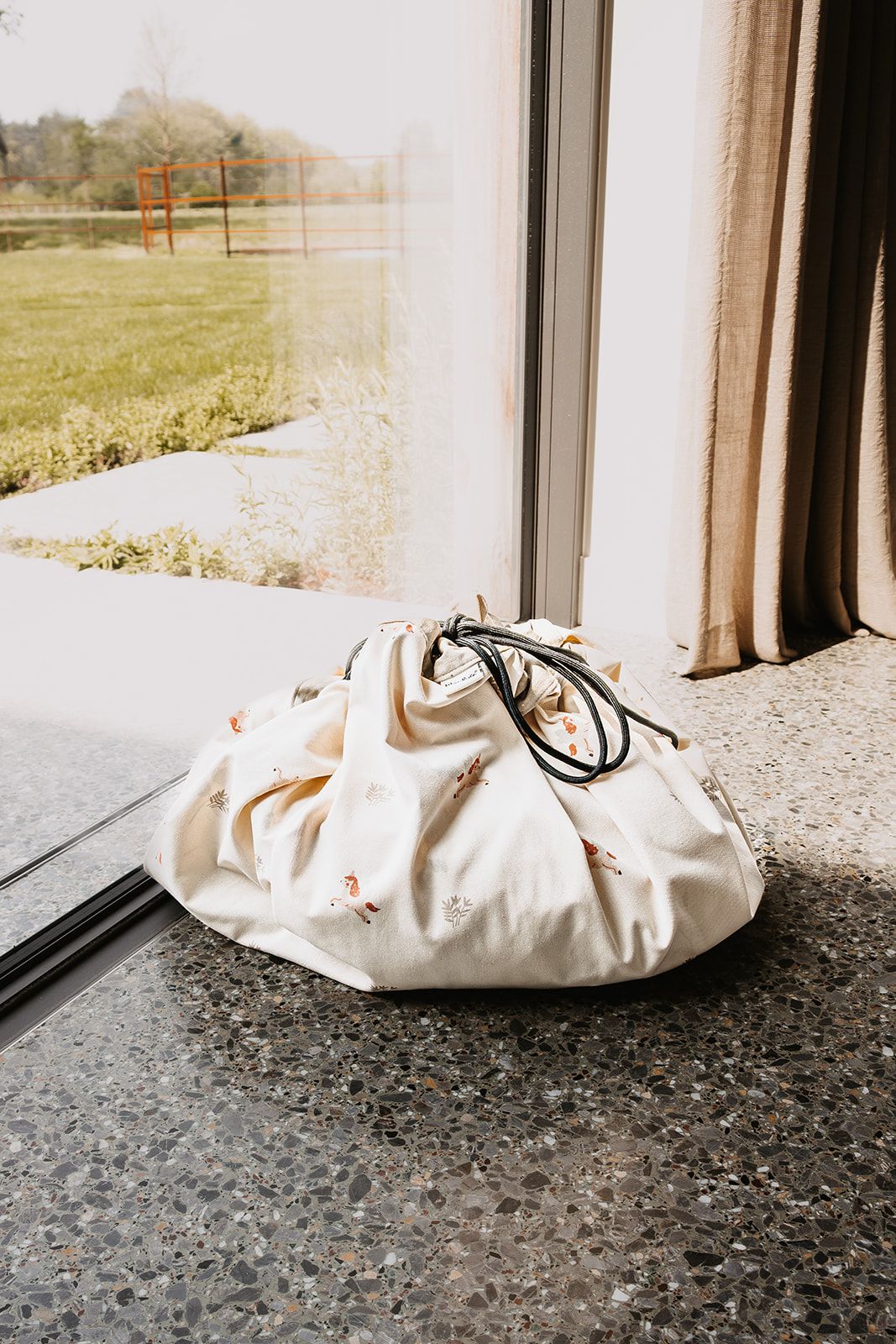 fairyworld toy storage bag and playmat, closed bag in front of the window