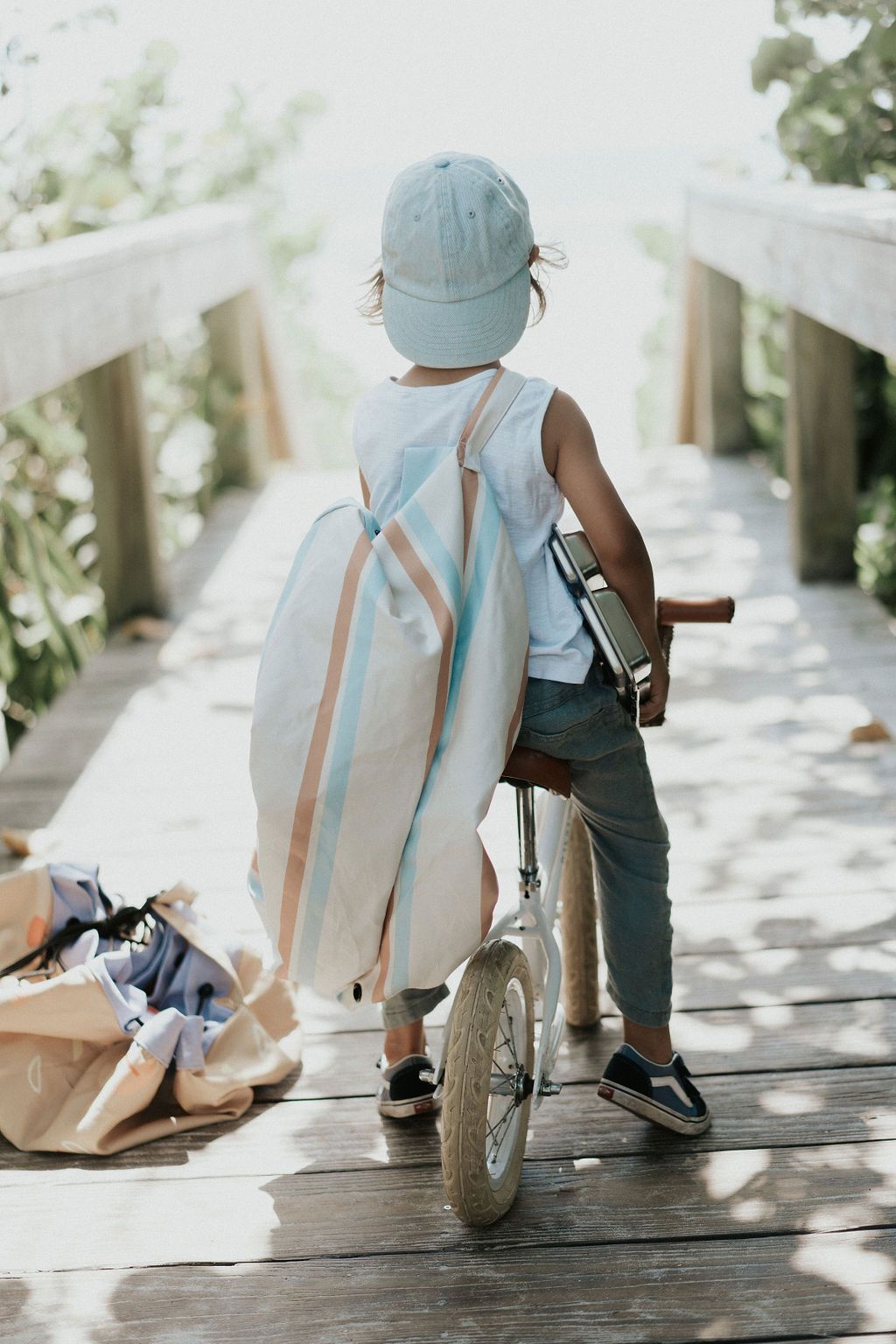 Play&Go outdoor storage bag and play mat, stripes, little boy with cap on bicycle on brigde