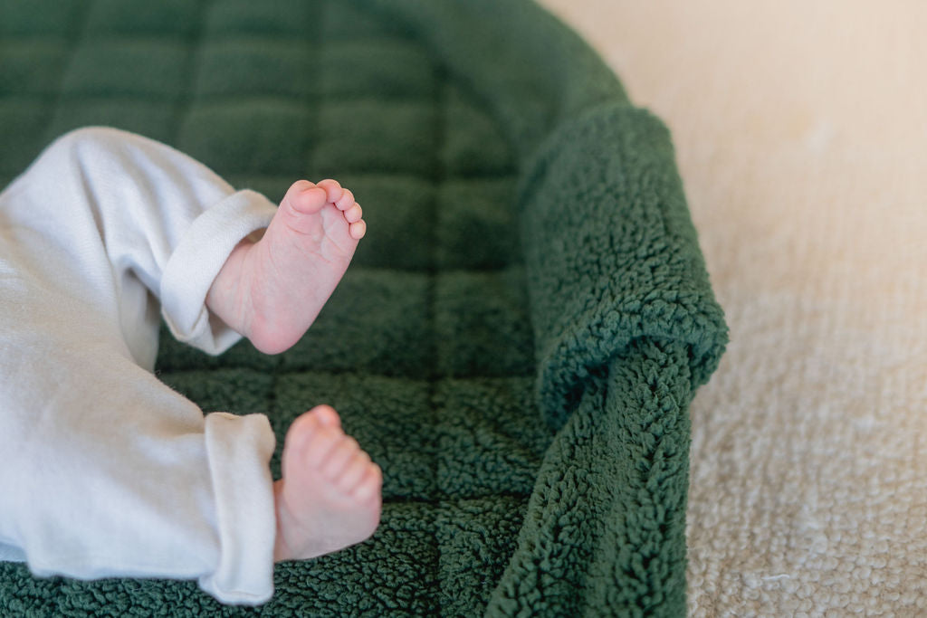 noomad soft teddy evergreen, little baby feet on open mat