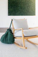 noomad soft teddy evergreen, closed bag is hanging on chair in living room
