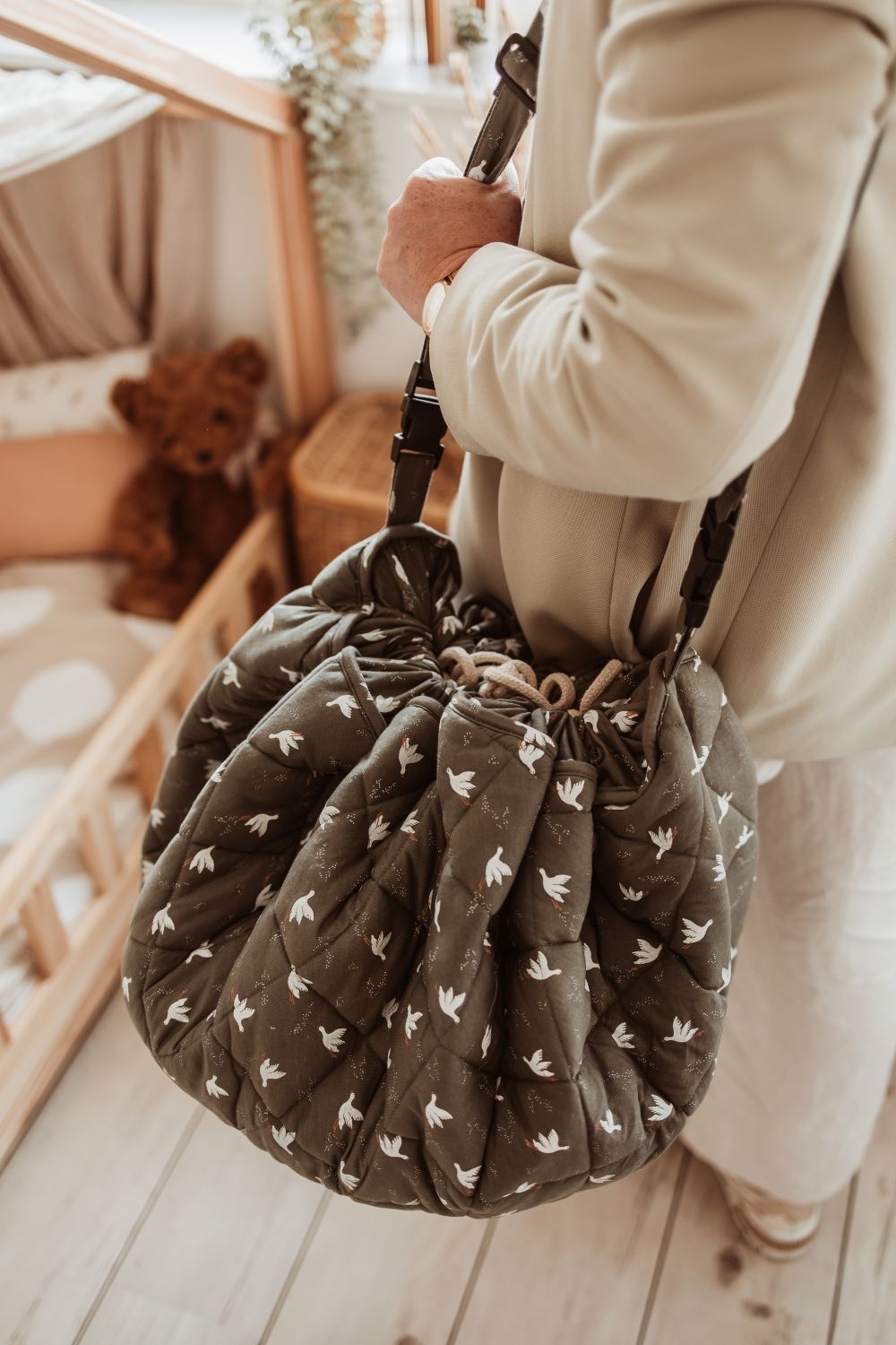 birds soft organic babymat, person is carrying the closed bag, using the shoulderstrap