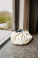 confetti toy storage bag and playmat, closed bag in front of window
