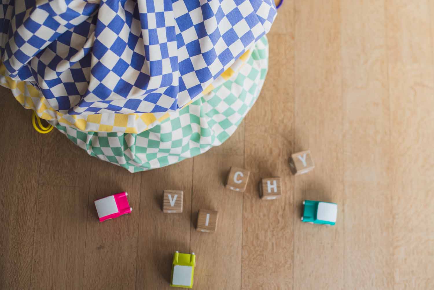 vichy toy storage bags piled on top of each other, wooden blocks en toys