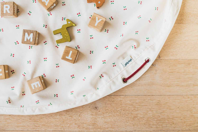cherry cherry toy storage bag, open on floor, wooden deer and blocks on the open mat
