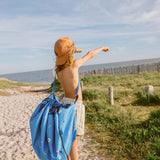 swim fun outdoor beach bag, child is carrying the bag at his shoulder with a shoulder strap, looking far away