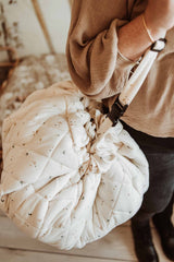 Moon organic babymat, person carrying the closed bag with a shoulder strap
