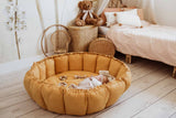 Bloom mustard organic babymat, little baby sleeping on mat, raised edges, bag in kidsroom, next to bed and cuddle bear