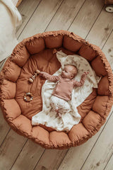 Bloom tawny brown organic babymat, raised edges, little baby sleeping on blanket on mat