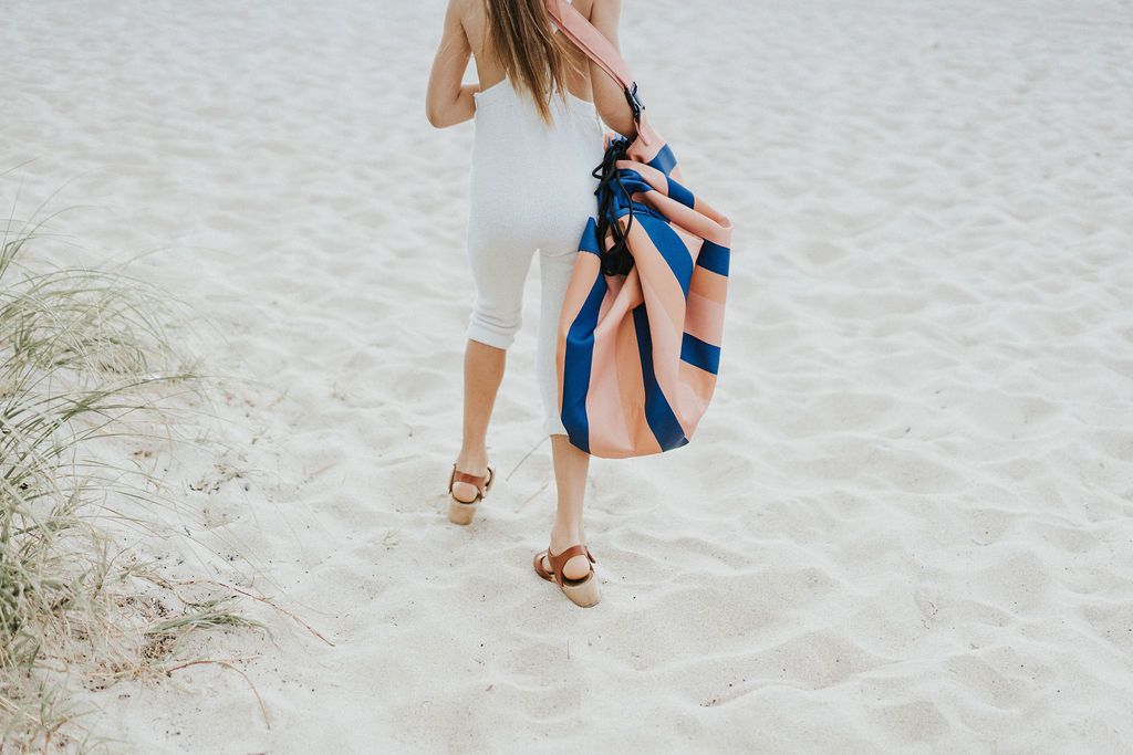 Play&Go outdoor storage bag and play mat, mokka stripes, girl carrying the bag while walking