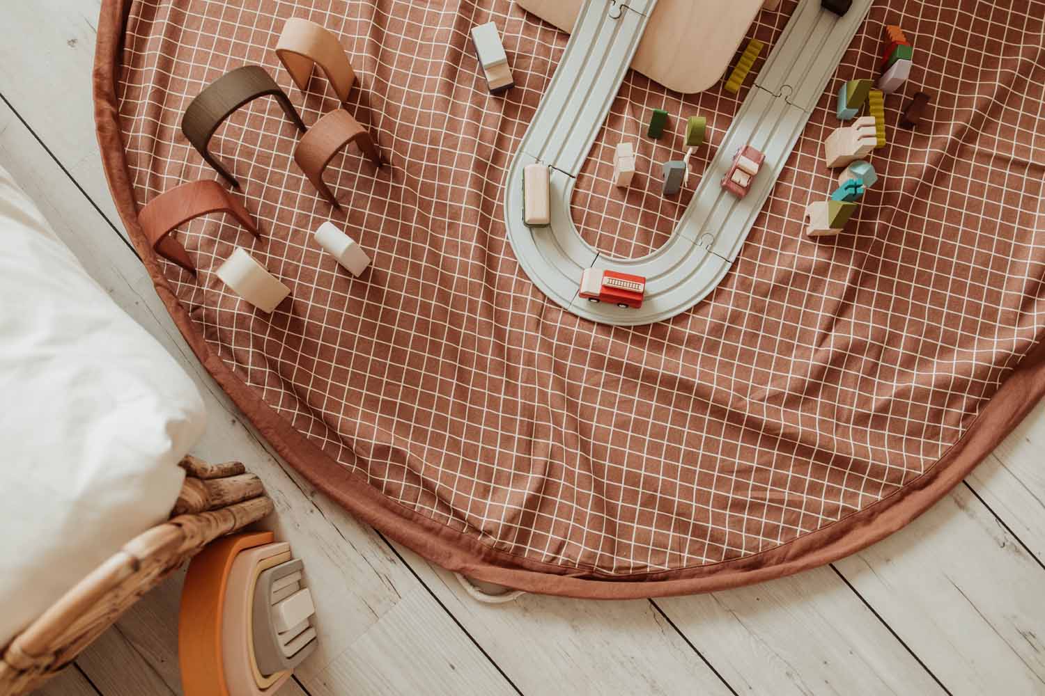 close picture of organic grid brown storage bag, lots of toys, road with wooden cars