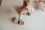 child playing with xylophone on dots puzzlemat